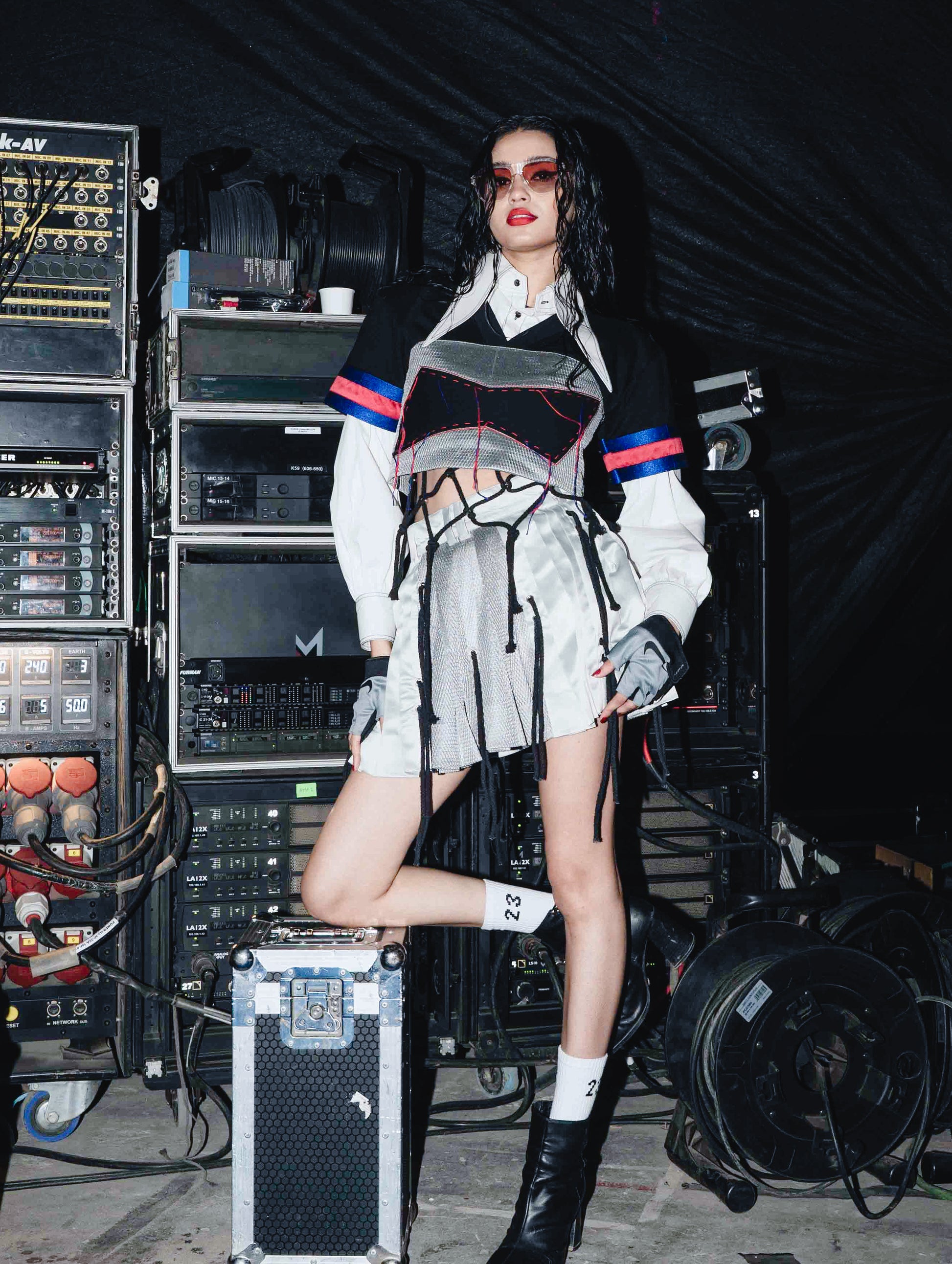Model backstage at the BUDXNBAHOUSE fashion show wearing Silver Mini SKirt with rivet and ropes detailing.