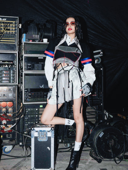 Model backstage at the BUDXNBAHOUSE fashion show wearing Silver Mini SKirt with rivet and ropes detailing.