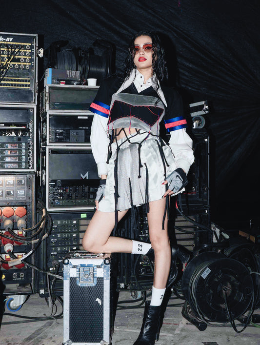 Model backstage at the BUDXNBAHOUSE fashion show wearing Silver Mini SKirt with rivet and ropes detailing.