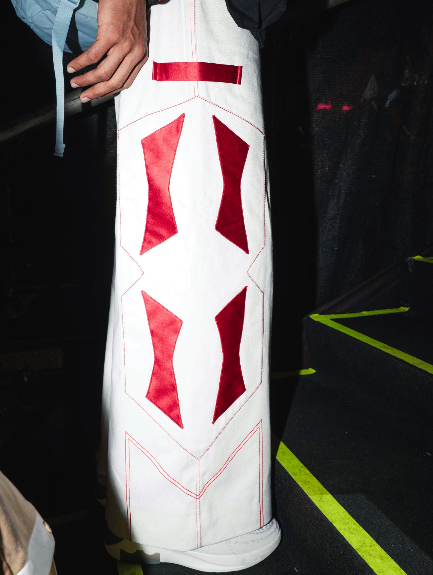 Closeup of the White denim jeans with Red Patchwork detailing for BUDXNBAHOUSE Fashion Show