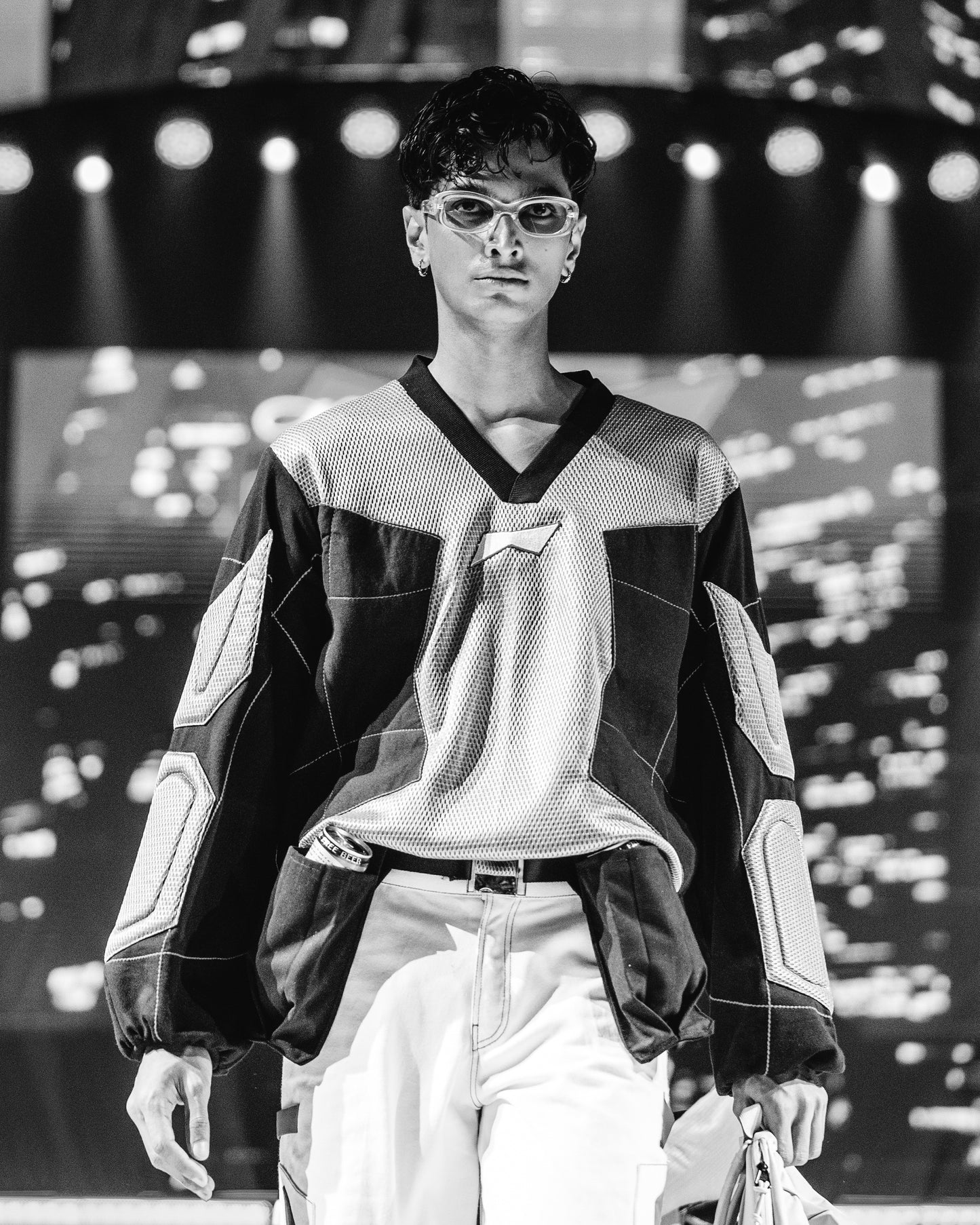 Model walking on a runway at a BUDXNBAHOUSE fashion show wearing Silver Black Patchwork T-shirt.