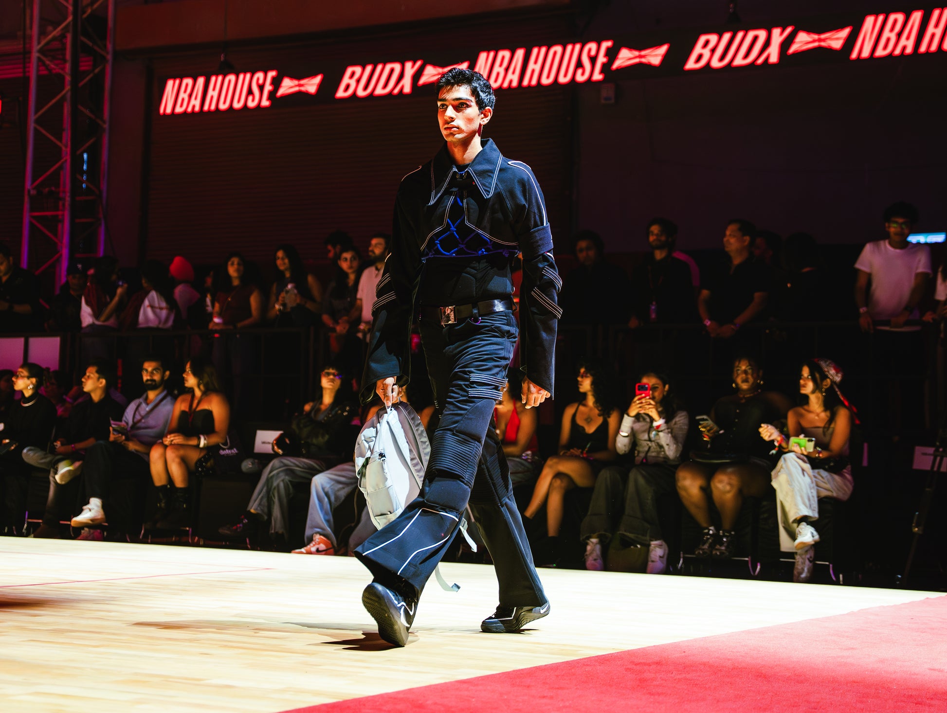 Model walking on a runway at a BUDXNBAHOUSE fashion show wearing Jett Muscle Padded Tank Top