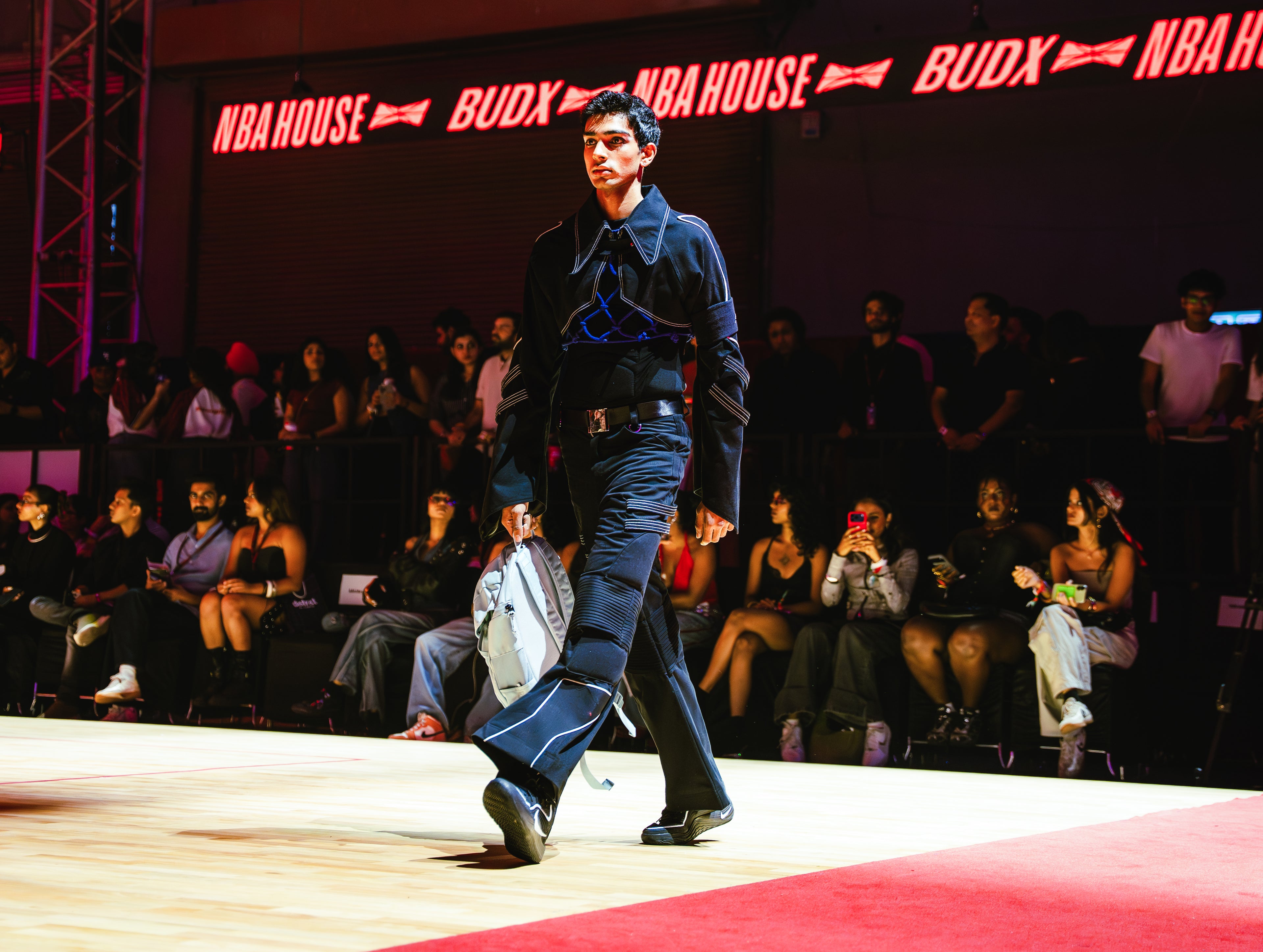 Model walking on a runway at a BUDXNBAHOUSE fashion show wearing Jett Muscle Padded Tank Top