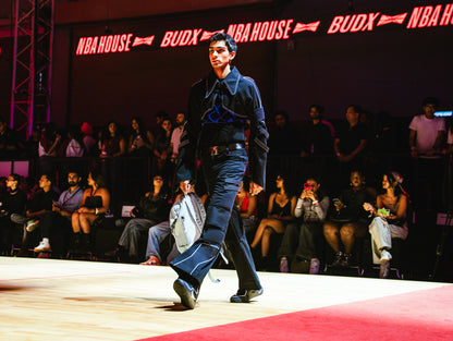 Model walking on a runway at a BUDXNBAHOUSE fashion show wearing Jett Muscle Padded Tank Top